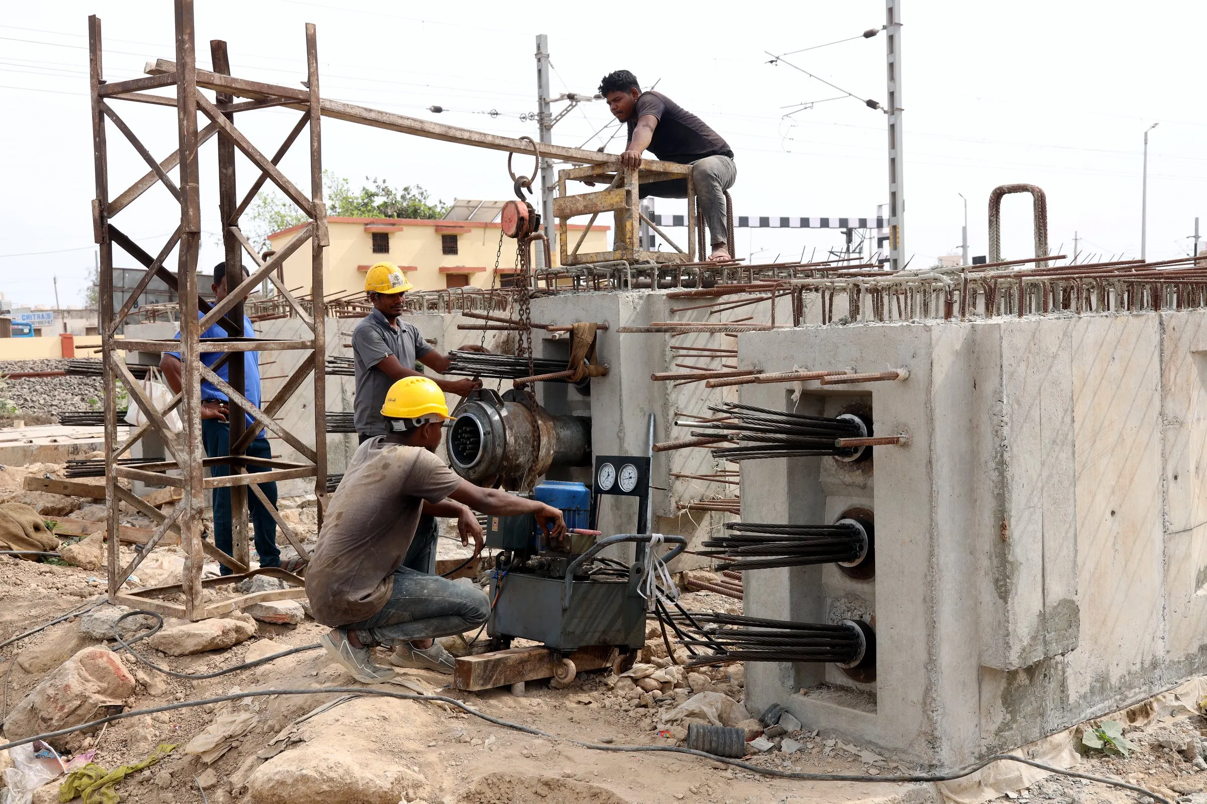 TYROS crew stressing a girder on the Okha railway bridge, Gujarat: multi-strand jack on the anchorage, power pack and gauges beside it